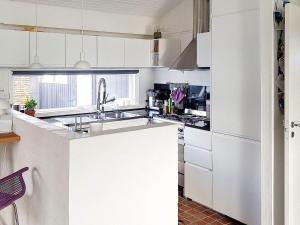 a kitchen with white cabinets and a sink at Holiday home Karrebæksminde XIII in Karrebæksminde