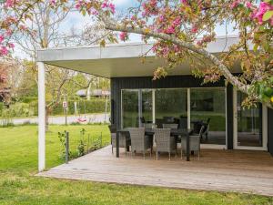 un patio con mesa y sillas en una terraza de madera en Holiday home Ebeltoft XXI, en Ebeltoft