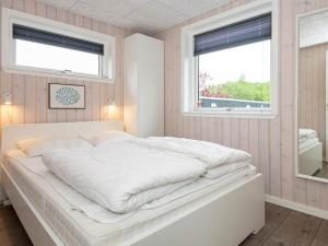 - un lit blanc dans une chambre avec 2 fenêtres dans l'établissement Holiday home Ebeltoft XXI, à Ebeltoft