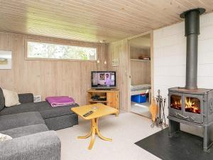 salon z kanapą i kominkiem w obiekcie 5 person holiday home in Hurup Thy w mieście Sindrup