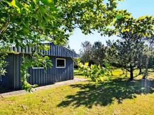 dom z niebieską bocznicą i ogródkiem w obiekcie 5 person holiday home in Hurup Thy w mieście Sindrup