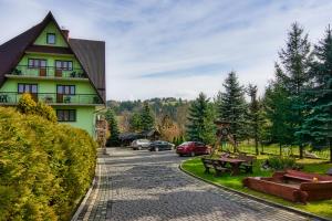 a house with a picnic table in front of a road at Kwatery Maciata in Biały Dunajec