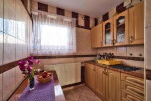 a kitchen with a table with a vase of flowers on it at Kwatery Maciata in Biały Dunajec