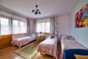 a bedroom with two beds and a table in it at Kwatery Maciata in Biały Dunajec