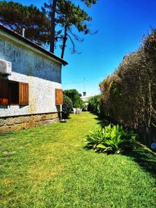 Vila ChãにあるCasa do Pinhal Guest Houseの草木の建物の隣の庭