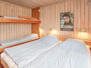 Pandrupにある6 person holiday home in Pandrupのベッドルーム1室(ベッド2台付)、壁にポスターが備わります。