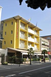 a person walking in front of a yellow building at Hotel Primo in Riva del Garda
