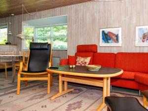 エーベルトフトにある6 person holiday home in Ebeltoftのリビングルーム(ソファ、テーブル、椅子付)