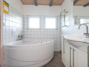 a white bathroom with a tub and a sink at 8 person holiday home in Hemmet in Falen