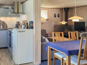 cocina y sala de estar con mesa y nevera en 4 person holiday home in S by en Nordost