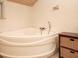 Strandbyにある8 person holiday home in Strandbyの木製の天井のバスルーム(白いバスタブ付)