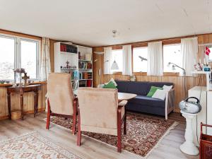 a living room with a couch and a table and chairs at 5 person holiday home in Fan in Fanø