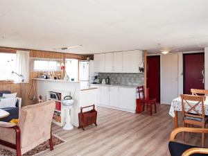 a kitchen and living room with white cabinets and a table at 5 person holiday home in Fan in Fanø