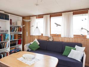 uma sala de estar com um sofá azul e uma mesa em 5 person holiday home in Fan em Fanø