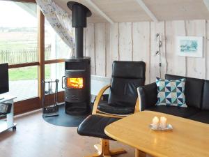 ein Wohnzimmer mit einem Kamin, einem Tisch und Stühlen in der Unterkunft 7 person holiday home in Broager in Broager