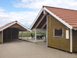 een huis met een overdekte patio met een tafel bij 7 person holiday home in Broager in Broager