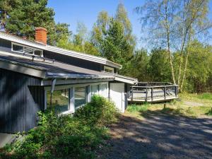 a house with a porch next to a forest at 14 person holiday home in Nex in Snogebæk