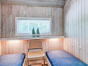 Vester Sømarkenにある8 person holiday home in Nexのベッド2台と窓が備わる小さな客室です。