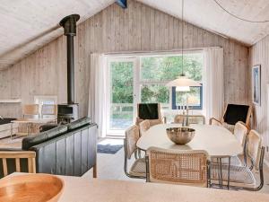 a living room with a table and chairs and a stove at Quaint Holiday Home in Nex with Beach nearby in Vester Sømarken