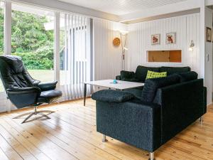 Sundstrupにある8 person holiday home in H jslevのリビングルーム(ソファ、テーブル、椅子付)