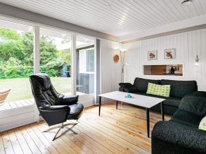 a living room with a couch and a table at 8 person holiday home in H jslev in Sundstrup