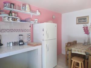 a kitchen with a white refrigerator and a table at Casa Luna in Cholula