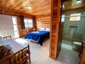 a bedroom with a bed and a shower in a room at Pousada Flor do Campestre in Urubici +94 photos