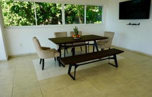 een eetkamer met een tafel, stoelen en een televisie bij Mexican Condo by the sea in Acapulco +9 foto's