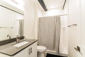biała łazienka z toaletą i prysznicem w obiekcie Amazing 1BR Loft Located Downtown w mieście Tucson