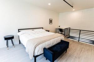 a bedroom with a large bed and a black stool at Amazing 1BR Loft Located Downtown in Tucson
