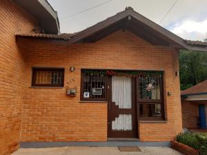 uma casa de tijolos com uma porta com uma coroa de Natal em Suíte Lago Negro em Gramado