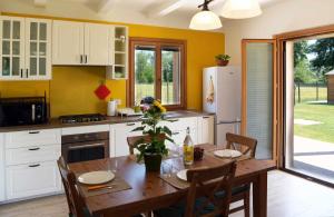 a kitchen with a table with chairs and a refrigerator at Casa Montefiore 13 Girasoli LT nella tranquilla campagna Marchigiana in Ancona