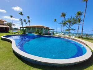 a large swimming pool in front of a house at Aldeia St Sebastien 31 Arembepe in Arembepe