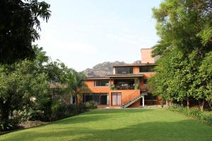 a house with a lawn in front of it at Hotel Quinta del Sol in Tepoztlán