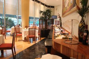 un ristorante con tavoli, sedie e bancone di Hotel Scala Magna a Città del Messico