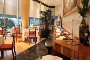 a restaurant with tables and chairs and a counter at Hotel Scala Magna in Mexico City