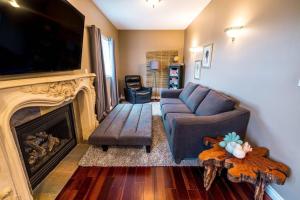 a living room with a couch and a fireplace at The River Blossom Suite - Downtown in Drumheller