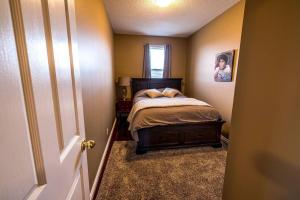 um pequeno quarto com uma cama e uma janela em The River Blossom Suite - Downtown em Drumheller