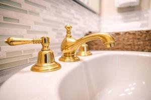 a bathroom sink with a gold faucet on it at The River Blossom Suite - Downtown in Drumheller