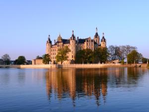 a large castle sitting on top of a large body of water at Gasthof Zur guten Quelle in Schwerin