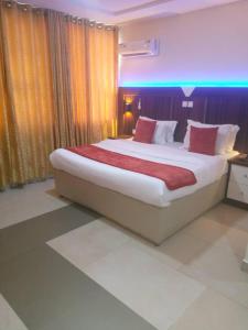 a bedroom with a large bed with red pillows at Citilodge Hotel in Lagos