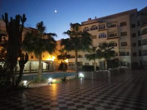 un cortile di un edificio con palme di notte di ARENA BEACH a Martil