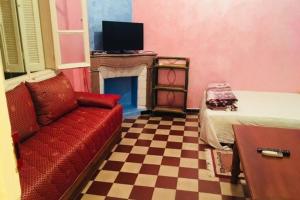a living room with a red couch and a fireplace at Nice 2 Bedrooms Apartment near the beach in Rabat