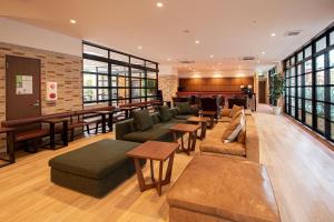 a lobby with couches and tables and a bar at ZONK HOTEL Hakata in Fukuoka