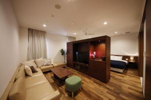 a living room with a couch and a bed at ZONK HOTEL Hakata in Fukuoka