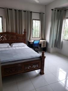 1 dormitorio con 1 cama, escritorio y ventanas en Izzahrah 4Rooms Shah Alam, en Shah Alam