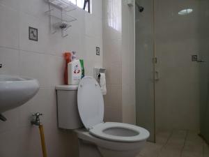 y baño con aseo blanco y lavamanos. en Izzahrah 4Rooms Shah Alam, en Shah Alam