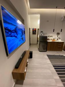 Platinum plus mirbat في صلالة: غرفة معيشة مع تلفزيون كبير معلق على الحائط