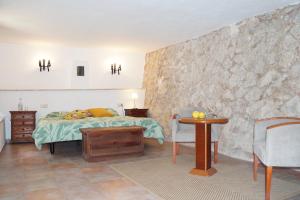 Schlafzimmer mit einem Bett und einem Tisch in der Unterkunft Agroturismo Finca Can Sec, SL in Lloseta