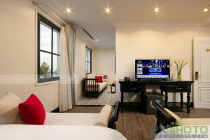 een woonkamer met een bank en een tv op een bureau bij Green Suites Hotel in Ha Long